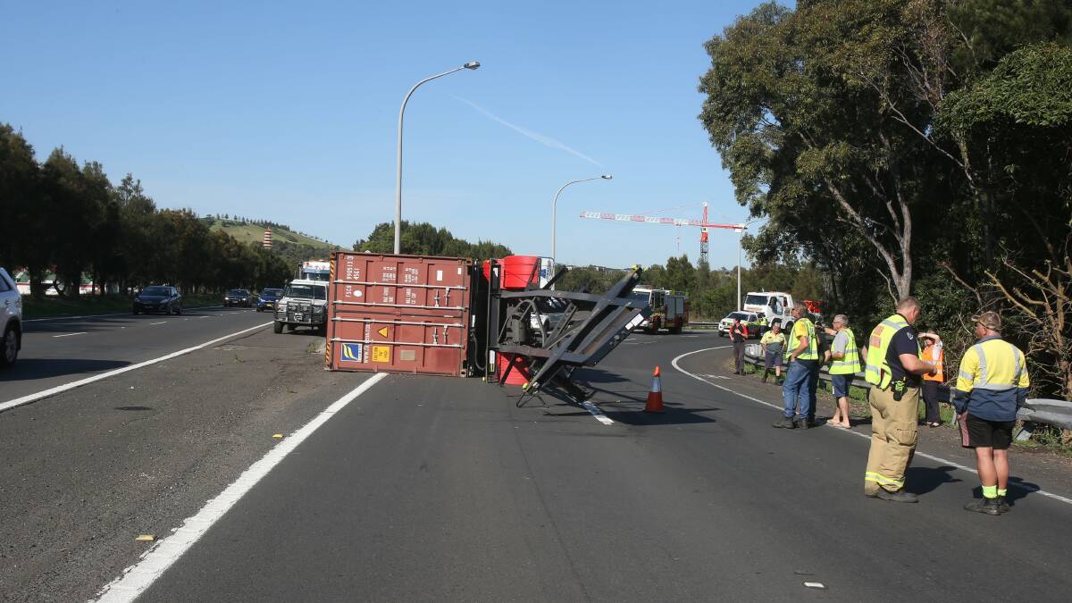 The truck driver, pictured right, with a Fire and Rescue NSW officer, walked away from the crash unscathed. Picture: Robert Peet.