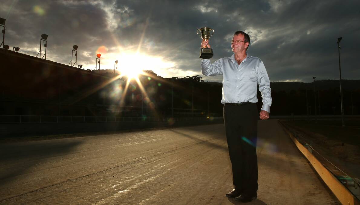 HEATS: Bulli Greyhound Club's Darren Hull holds aloft the Bulli Cup trophy on the track. Picture: Kirk Gilmour