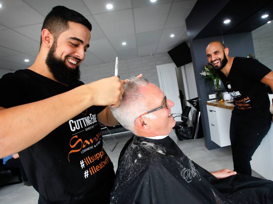 I'll stand with you: Dozens turn up for a haircut from barber Bilal El-Mohamad to show support after his business was defaced by graffiti. Picture: Sylvia Liber.