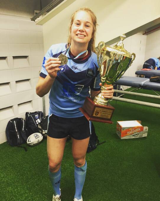 True Blue: Kezie Apps celebrates with the interstate trophy and best player medals after NSW's victory last year. 