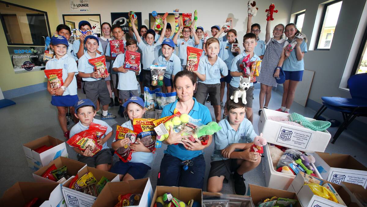 WELCOME DONATION: Janelle Kalkan from Unanderra RSPCA shelter gladly accepts the food and toy donations from Berkeley Public School students, including (front) Liam Nyers Saunders, Libby Myles and Jett Pertovt. Picture: Sylvia Liber