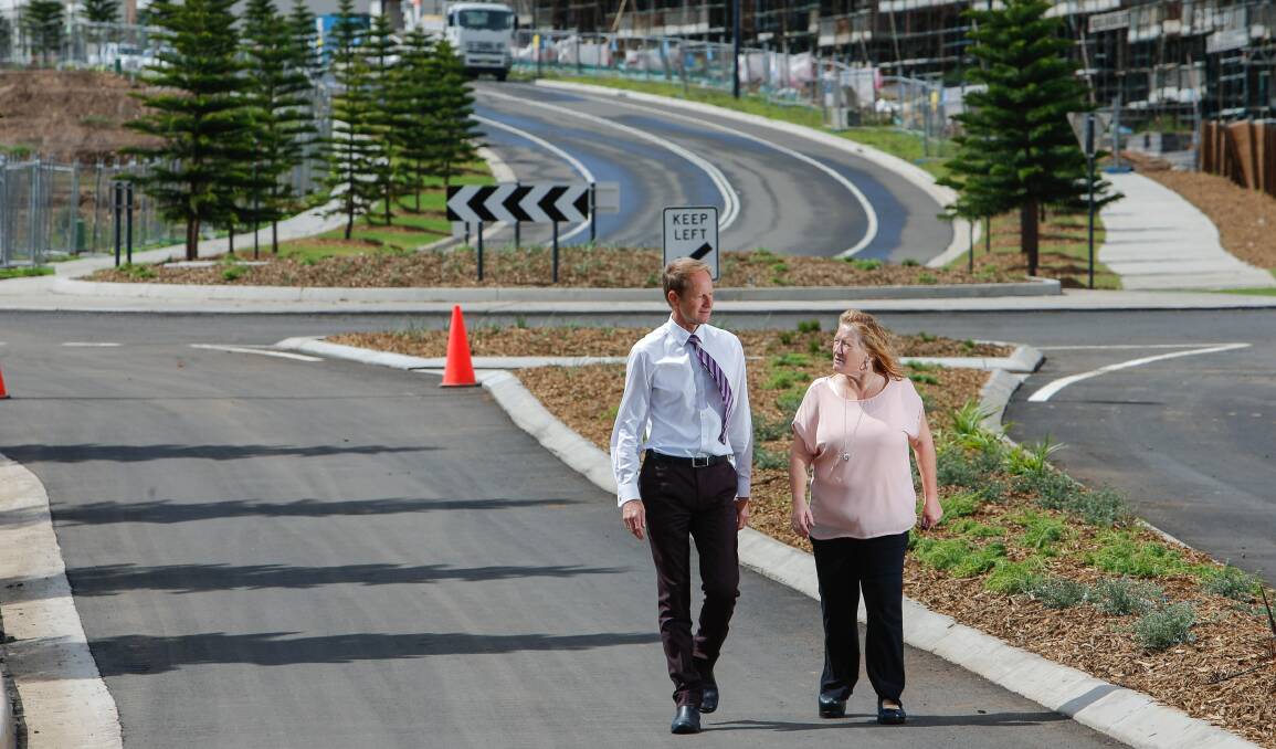 work goes on: Development director Glenn Colquhoun and Shellharbour City Mayor Marianne Saliba walk along Shell Cove's new Harbour Boulevard. Picture: Adam McLean