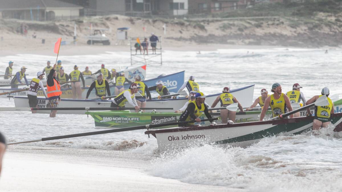 Ready to go: Teams take a final look at the conditions before launching in the Navy Surf Rowing League event held at Shellharbour beach.