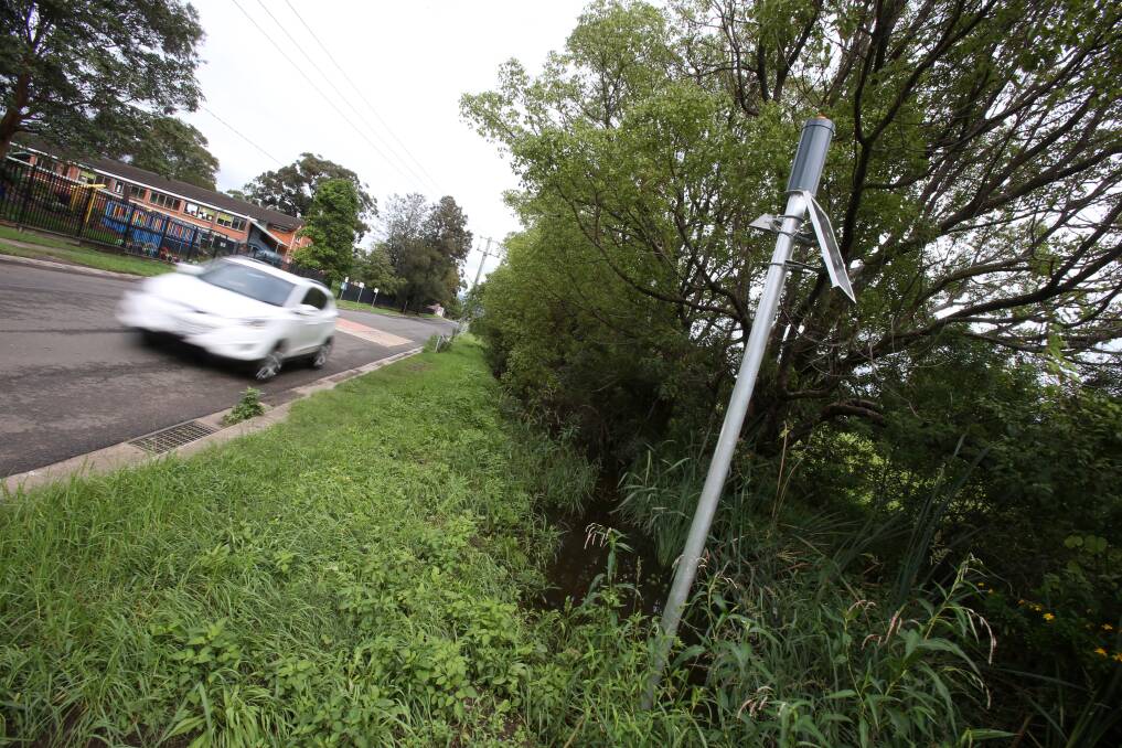 WARNING: This humble 'DipStik', installed on Taylors Rd Albion Park in November, alerts the SES and public to rising flood water. Picture: Robert Peet