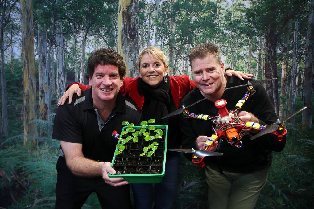 GREEN THUMBS: Ian McColm, Juliet Scrine and Ben Roberts with baby Illawarra Flame Trees and a drone that will take flight during a new festival. Picture: Sylvia Liber