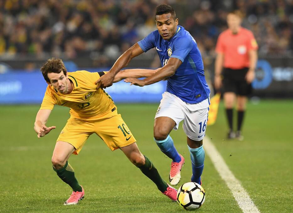 Out of the way: Robbie Kruse tussles with  Alex Sandro Silva of Brazil. Picture: Quinn Rooney/Getty Images
