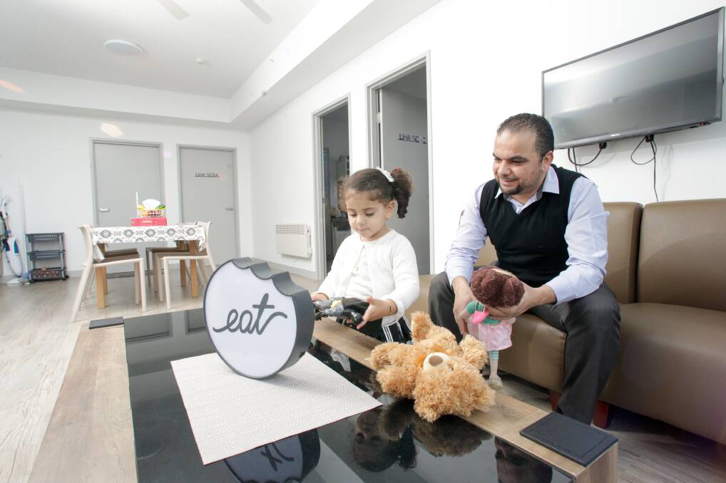 PLAY TIME: University of Wollongong PhD student Faisel Tubbal and his three-year-old daughter Baraa relax in their Bangalay three-bedroom unit. Picture: Adam McLean