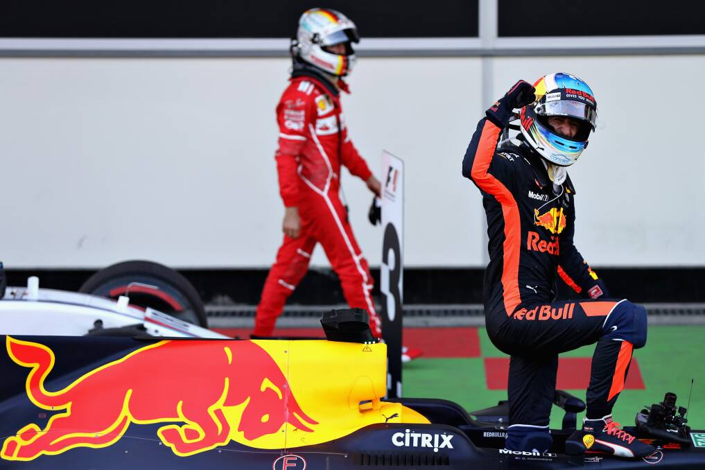 Pumped up: Daniel Ricciardo celebrates his win as Sebastian Vettel owalks past at the Azerbaijan Formula One Grand Prix. Picture: Mark Thompson/Getty Images
