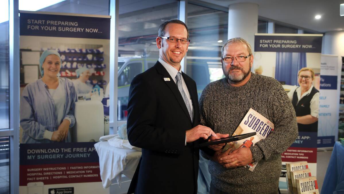 Easy to operate: Clinical nurse consultant James Brinton showcases the My Surgery Journey app and magazine to a patient's family member Andrew Brierley at the recent launch at Wollongong Hospital. Picture: Sylvia Liber