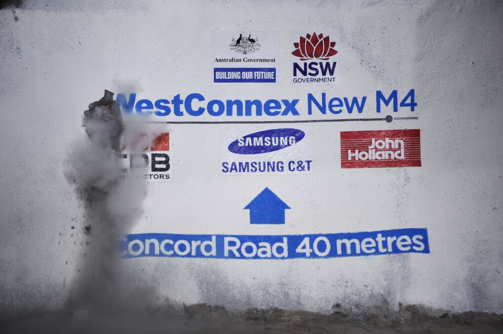 Workers breaking through during tunnelling for WestConnex ... Wollongong MP Paul Scully has raised concerns about plans to dump excavated rock and soil from the project to Port Kembla. Picture: Nick Moir