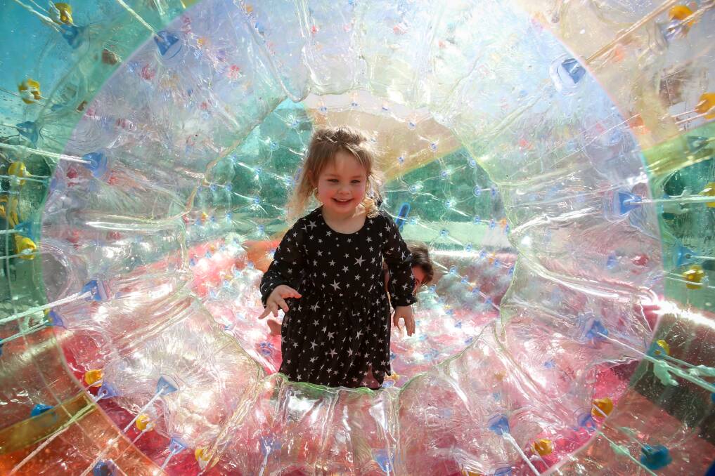 Four-year-old ​Rylee Giblett plays in the inflatable tube at the Dapto street fair. 