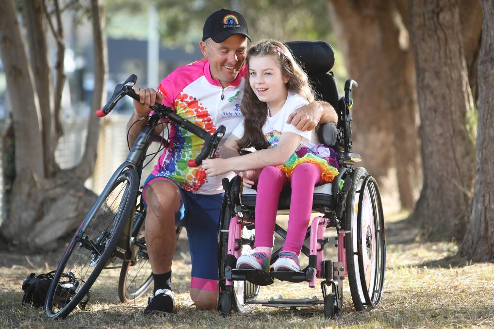 Rough ride: Grant Saxby with his daughter Chloe who is one of seven Australians with the rare Vanishing White Matter disease. He is leading a ride from Melbourne to Wollongong to raise funds for research. Picture: Adam McLean