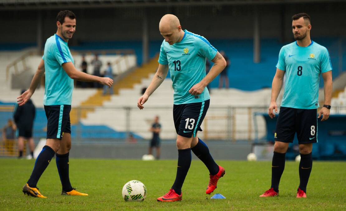 World at his feet: Socceroos (from left) Ryan McGowan, Aaron Mooy and Bailey Wright at training in Honduras.