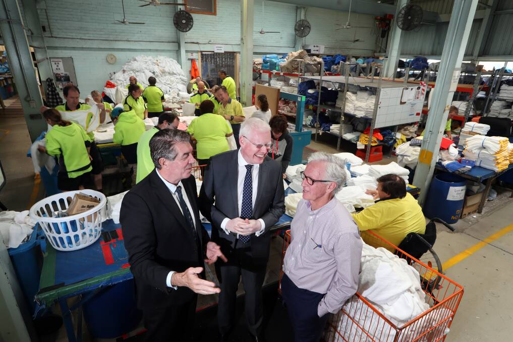 Funding boost: NSW Disability Services Minister Ray Williams with Parliamentary Secretary for the Illawarra Gareth Ward and Flagstaff CEO Roy Rogers at the Unanderra facility's commercial laundry. Picture: Sylvia Liber