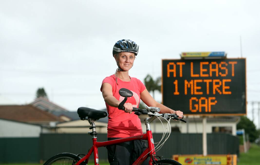 Stay away: Wollongong City Council road safety officer Naomi Reid with one of the council's road signs reminding drivers to leave space around cyclists. Picture: Sylvia Liber