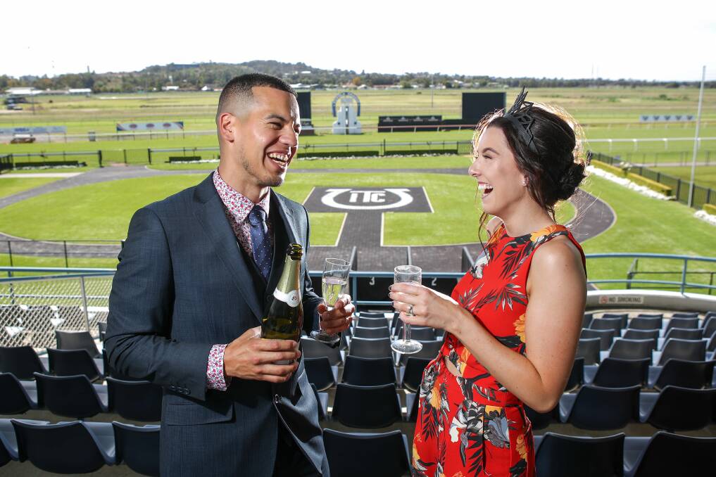 Derek Quiros is dressed in Oxford and Lauren Petrovski in Cue - having laughs and bubbles at Kembla Grange racecourse ahead of Melbourne Cup Day celebrations on Tuesday. Picture: Adam McLean