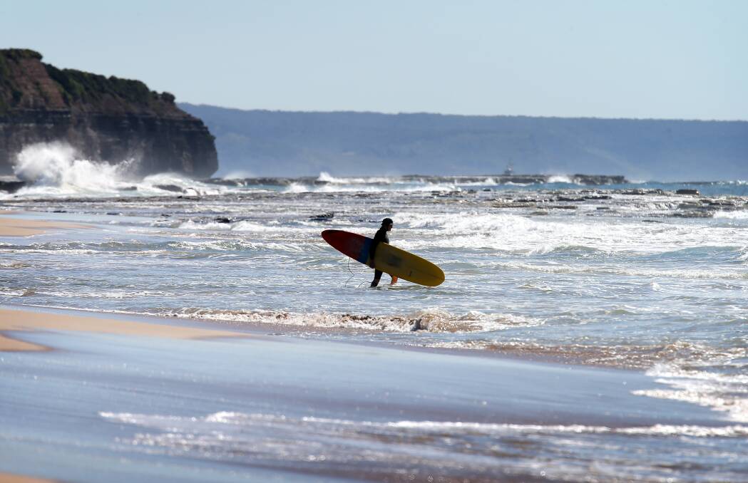 Stay frosty: A surfer ventures into the water at Thirroul Beach on Wendesday. Illawarra beaches are all rated as clean. Picture: Sylvia Liber