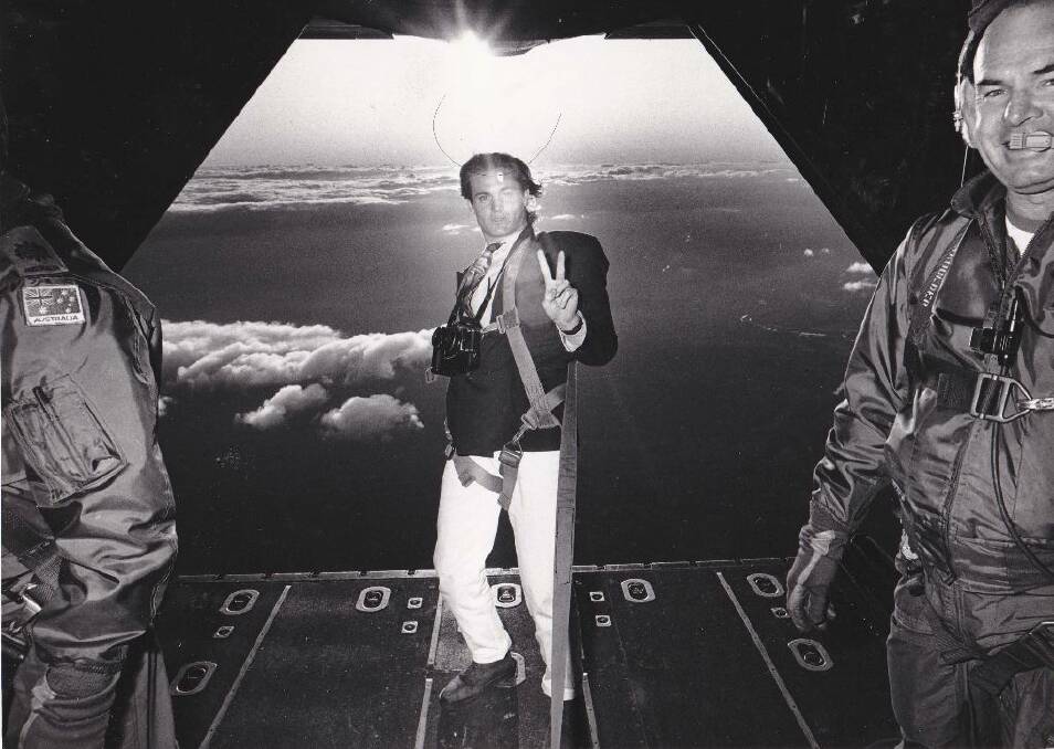 Journalist Steve Gee gives the peace sign in the back of a RAAF Hercules aircraft above Jervis Bay in 1992. Picture: Kirk Gilmour