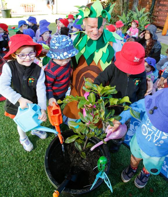 Let it grow: Clive Bohmer in character as "Woodnutt" and some students of Kids Korner preschool at Balgownie get into the tree-planting spirit. Picture: Adam McLean
