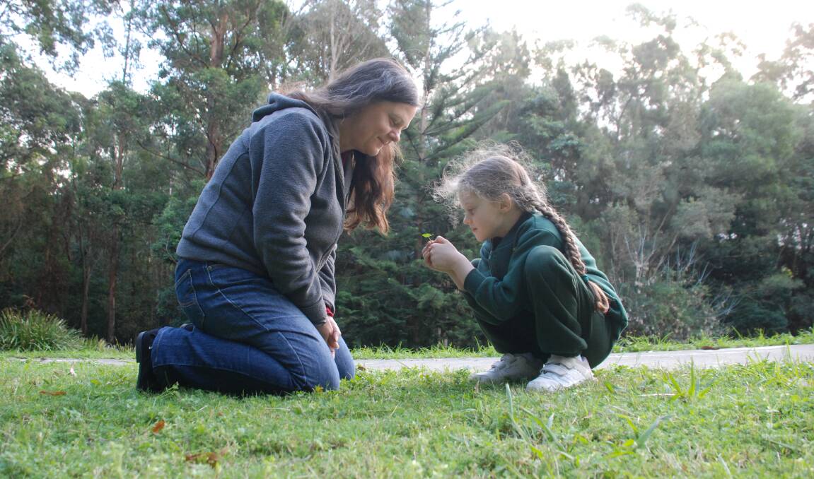 Lucky spot: Tina Hanneman and her daughter Amelia Wechner admire a four-leaf clover they found in Nyrang Park on Friday afternoon. Picture: Ben Langford