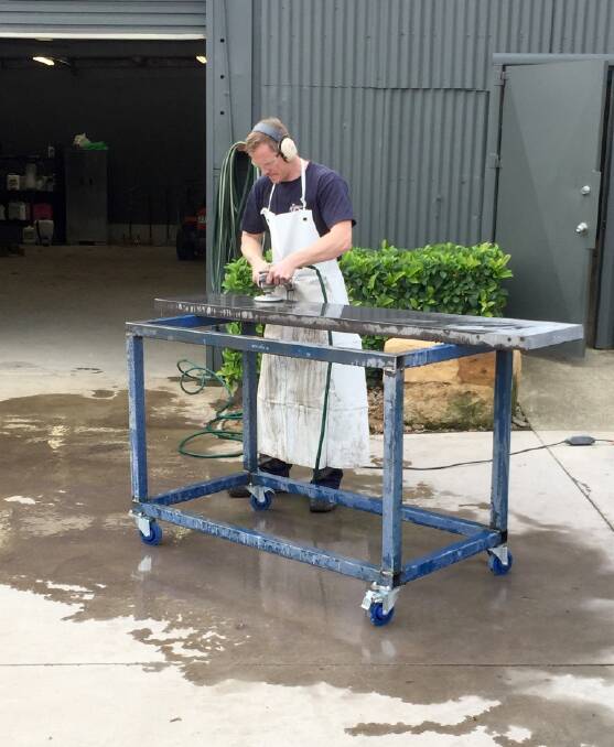 Jared Evans working on one of his polished concrete bench tops, ensuring a consistent finish for the surface