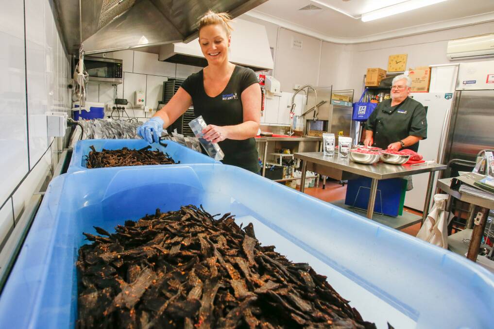 Leah Stefanou packs the jerky for sale while Ron Kuhna slices the topside before it is marinated and then dried for nine hours. That would be the chilli seeds in foreground. Picture: Adam McLean