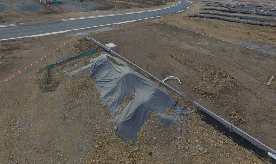 Containment: Contaminated aggregate can be seen coming out from under the plastic sheeting. Picture: DAVID ROZADILLA.