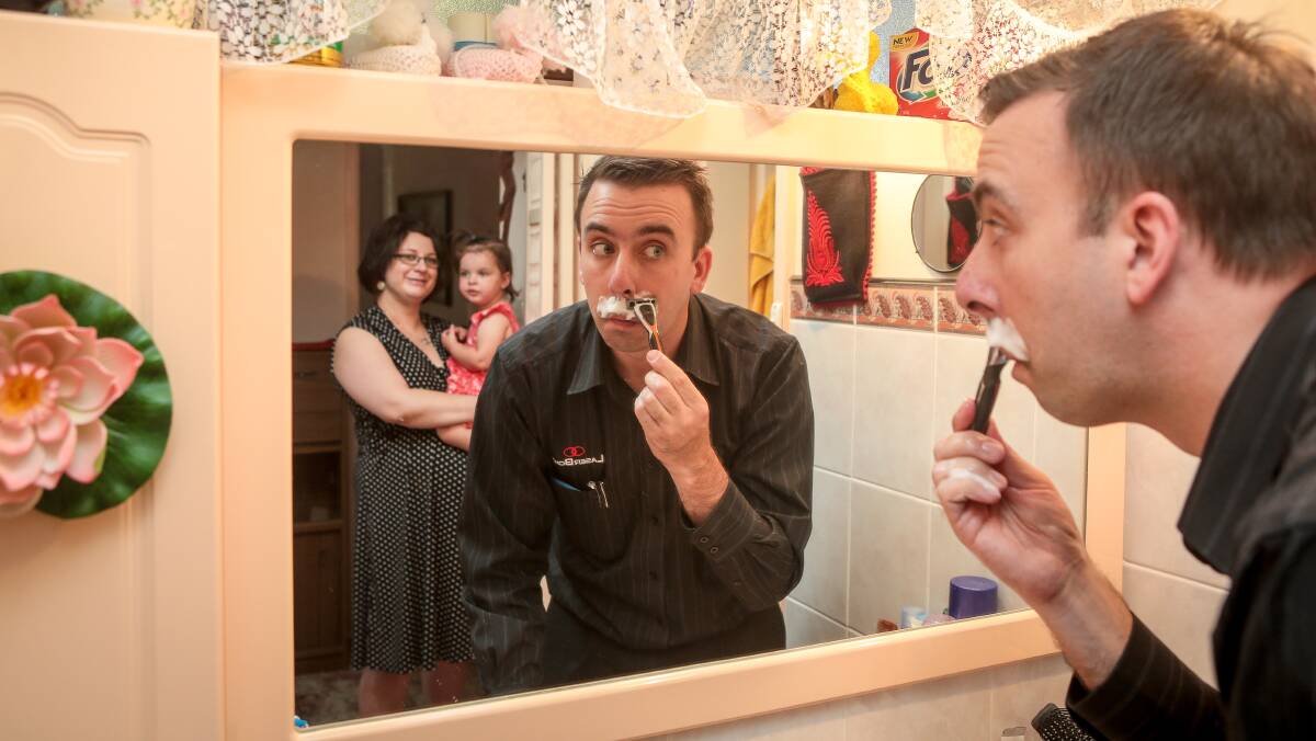Mo Bro: Mount Warrigal's Justin Suwart shaves off his impressive moustache, to the delight of wife Sheena and daughter Eva. Picture: Adam McLean