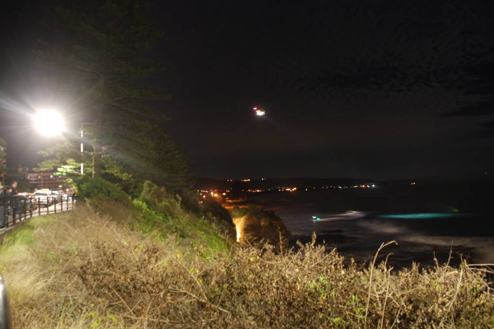 A chopper scours waters off North Beach in search of a lost night swimmer. Picture: Angela Thompson