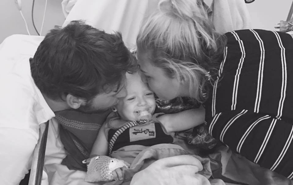 Brave face: Tyde O'Neill, with his parents Ross and Ashleigh, is battling high risk leukaemia - most days with a smile on his face. Pictures: Supplied