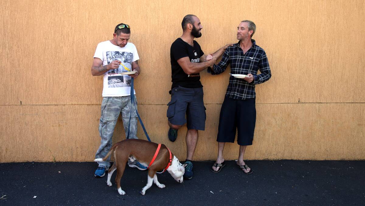 Omar Nemer from Samara's restaurant (centre) supplies lunch to Tim Illingworth, with his dog Conan, and Jasmin Perdriau at Wollongong Homeless Hub on Monday. Picture: Sylvia Liber