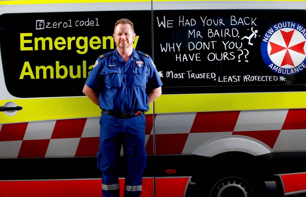 Chalk talk: Illawarra paramedic, and HSU delegate, Rod Hatton hopes that slogans written on ambulance windows will raise public awareness of cuts to paramedics' insurance cover. Picture: Adam McLean
