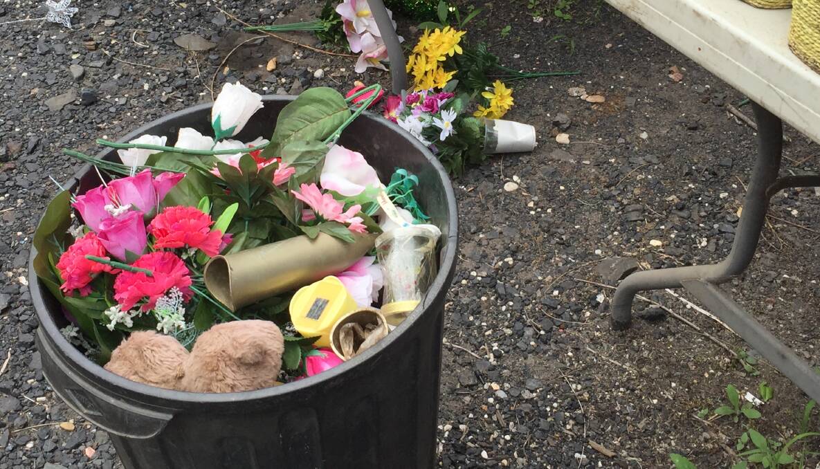 Discarded: Trestle tables and garbage bins full of ornaments, artificial flowers and other gifts were left at Lakeside Memorial Gardens for grieving parents to pick through. Picture: Supplied.