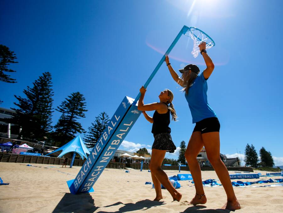 SETTING UP: Sarah Wall and Brie Reichman set up the 10-netball courts at North Wollongong Beach ahead of the Beach Netball event on October 14-16.