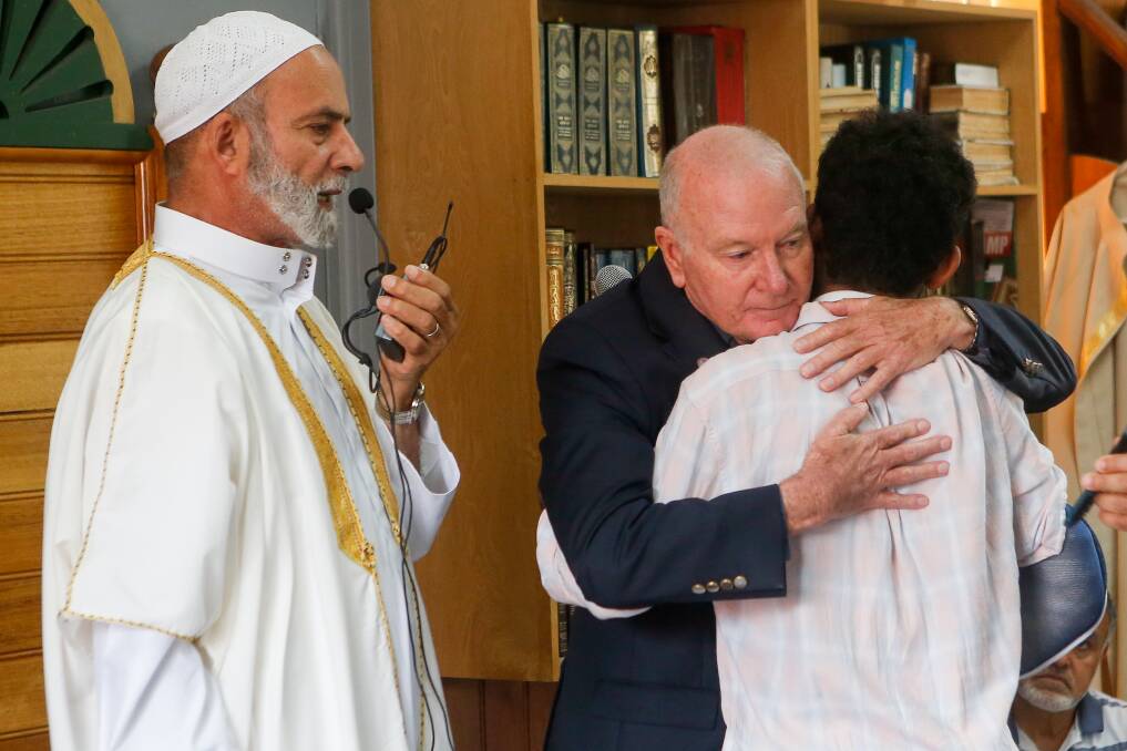 Imam Sheikh Abdul Rahman looks on as Wollongong Lord Mayor Gordon Bradbery embraces Yousuf Alsaadi. Picture: Adam McLean