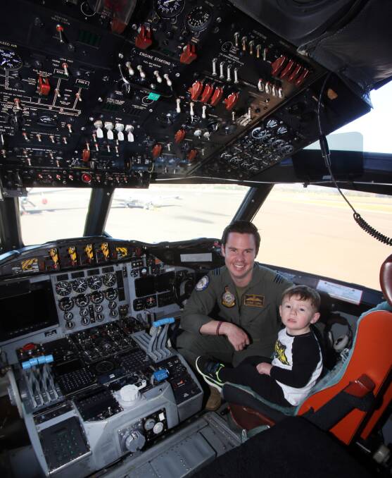 PRIME VIEW: Flight lieutenant Thomas Fleming with Thomas Neaves from Albion Park in the cockpit of the RAAF AP3C ORION Sub Hunter. Pictures: Robert Peet
