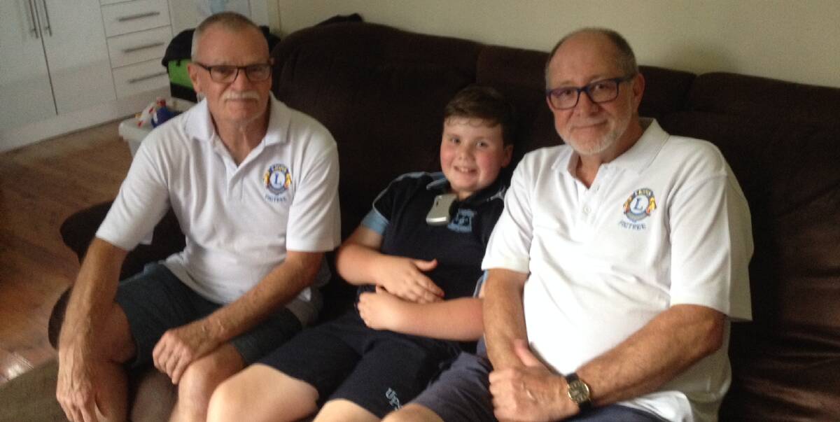 THANKS AMIGO: Figtree Lions Club president Peter Brown (left) and secretary Jim Tolerton with 10-year-old Jesse Hampton after he received his Amigo FM transmitter device. Picture: Supplied