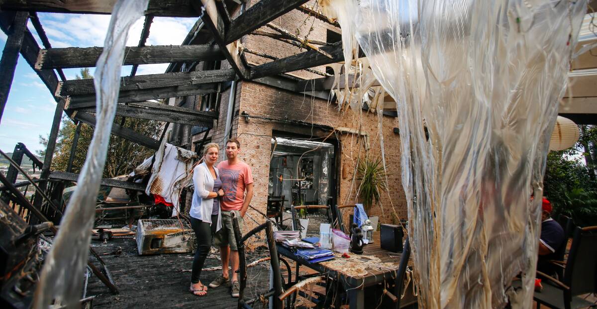 MESS: Figtree couple Lani and John Balzan survey the damage at the back of their Cameron Place home which was badly damaged by fire. Picture: Adam McLean