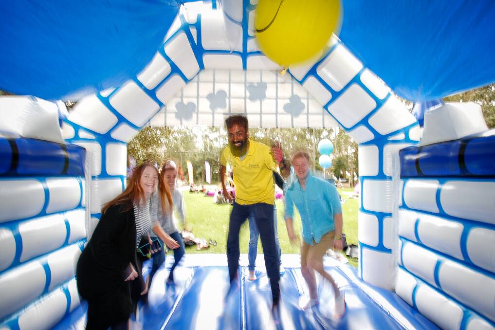 JUMPING FOR JOY: UOW Wellbeing coordinator Ninan Mathew and university students enjoy the jumping castle on the first day of the three-day WOW Festival on campus. Picture: Adam McLean