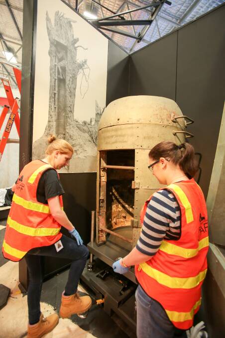 Australian War Memorial staff Eliza McKenna and Kassandra O'Connell installing an observation post at the Spirit of Anzac Centenary Experience. 