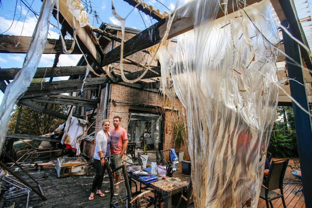 MESS: Figtree couple Lani and John Balzan survey the damage at the back of their Cameron Place home which was badly damaged by fire. Picture: Adam McLean