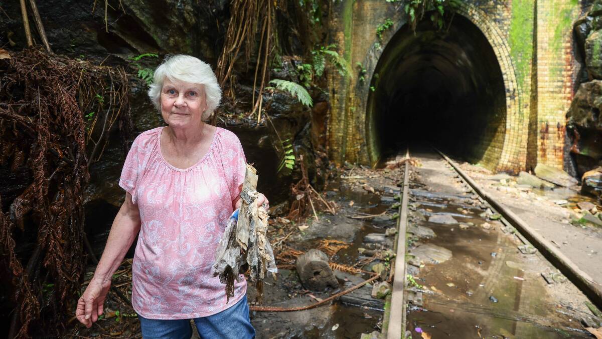 Merilyn House, a member of Landcare and the wife of Mr House, holding a collection of discarded plastic bags she's picked up along the rail line. 