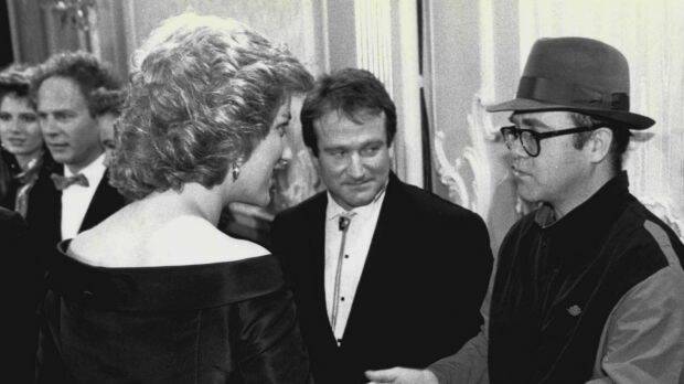 Princess Diana meets one of her favourite performers Elton John (with Robin Williams looking on). Photo: Express Newspapers

