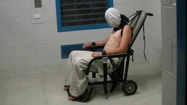 Dylan Voller is hooded an strapped into a restraining chair in the footage. Photo: ABC Four Corners

