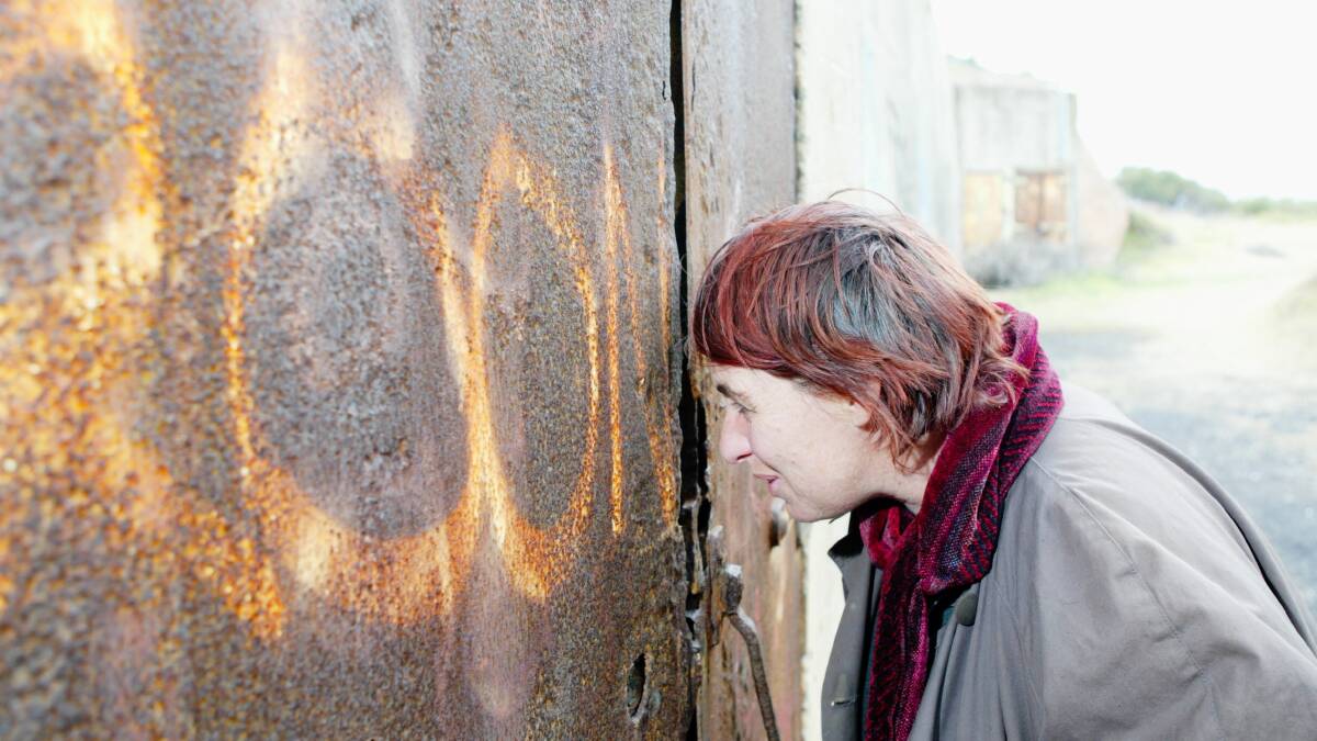 Jenny Briscoe peers through the welded shut doors of the old battery.