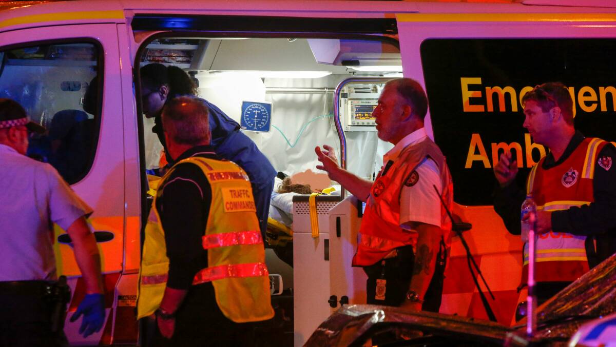 A man is loaded into an ambulance and taken to Wollongong Hospital under police escort. Photo: Adam McLean