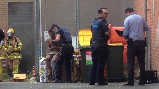 Police speak with a man at the back of the Commonwealth Bank branch. Photo: Ernie Gonzalez

