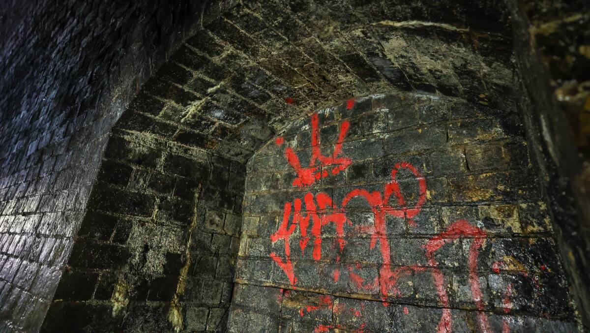 Red graffiti on the walls of the tunnel. Helensburgh's Landcare Group holds regular clean-ups to remove the paint.