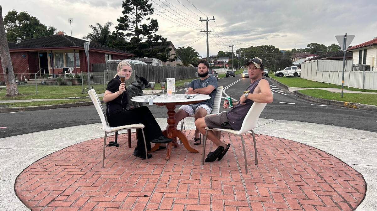 Jarrod and Kirsty, and an unnamed local with his dog, enjoy a drink at the roundabout. Picture by Mary Jackson