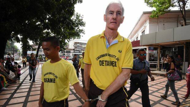 Peter Scully (right) arrives at the Cagayan De Oro court handcuffed to another inmate on his first day of his trial.  Photo: Kate Geraghty
